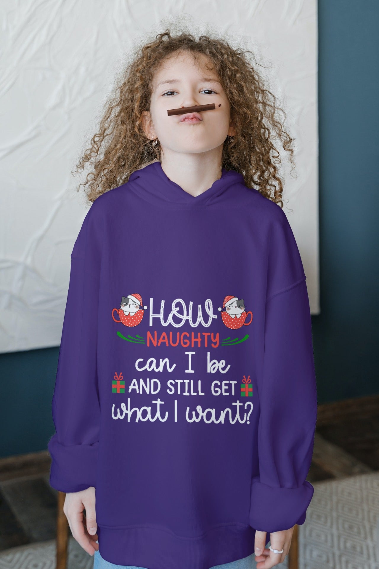 girl wearing a purple sweatshire with Christmas themed design 